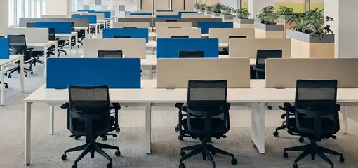 Modern open-plan office space featuring clean workstations, ergonomic chairs, and sanitized carpets provided by professional office cleaning services in Bloomington, IN.